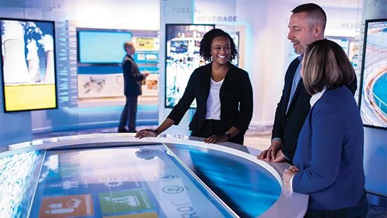 business people grouped around large computer display